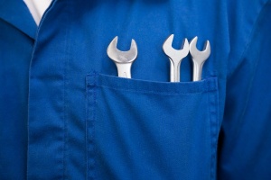 Truck repair mechanic with wrenches in pocket